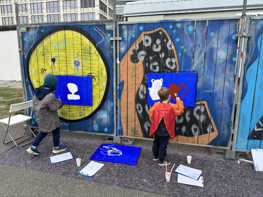 Kinder malen auf Leinwände an der East Side Gallery